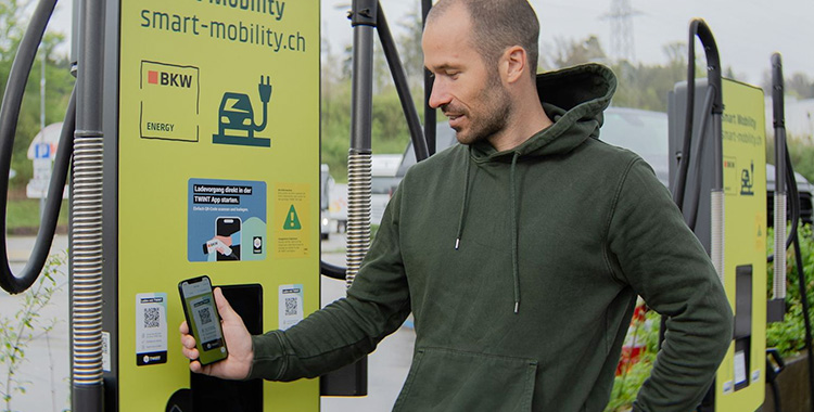 Junger Mann beim Auflagen seines E-Autos an einer Ladesäule