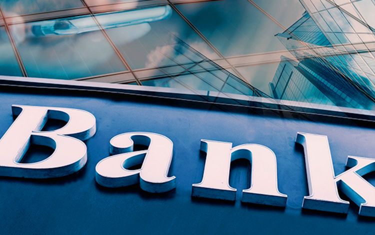Schriftzug Bank vor einer spiegelnden Fassade