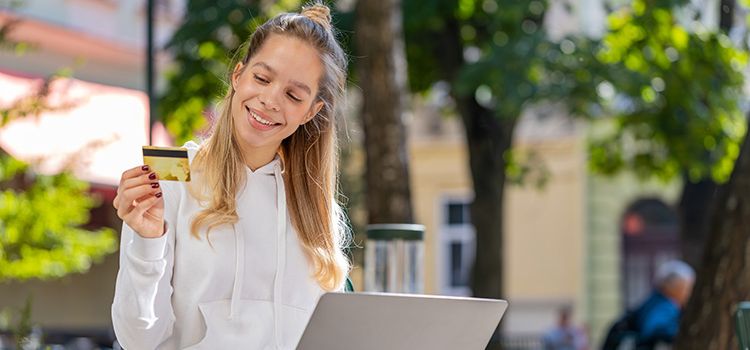 Junge Frau mit Kreditkarte und Laptop